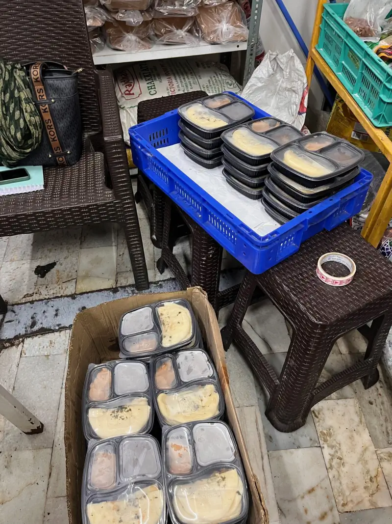 Sealed meal trays loaded into crates, ready to leave the kitchen